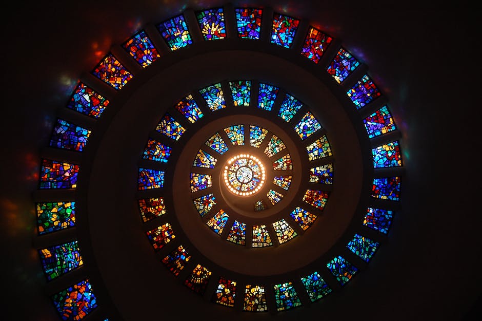 Image of medieval gothic stained glass depicting biblical scenes and saints, serving as visual and emotional religious instruction for illiterate individuals in medieval society.